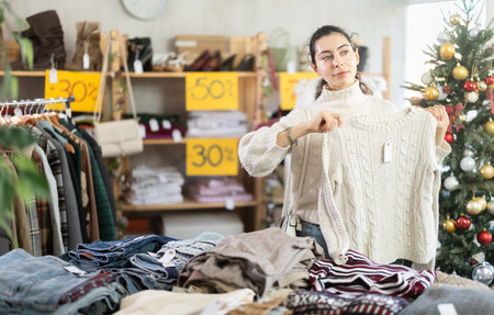 girl near showcase pick out and buying sweater, New Year eveの写真素材