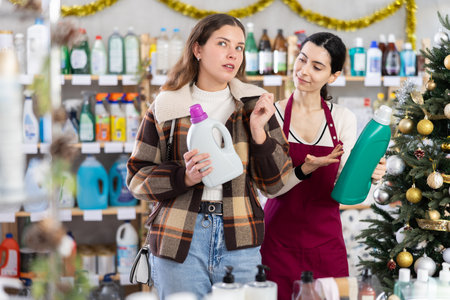 Girl consultant helps female buyer choose laundry softenerの写真素材