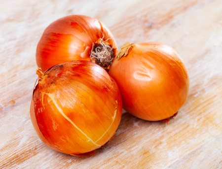 Fresh onions lying on a wooden surfaceの写真素材