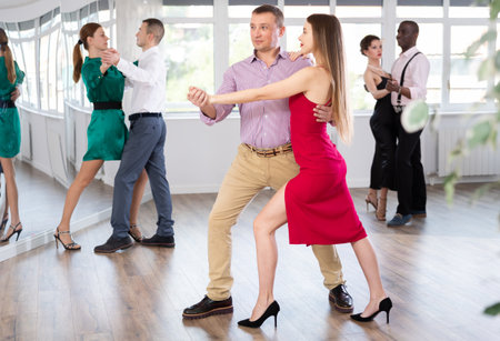 Man and young woman practicing waltz in dancing studioの写真素材