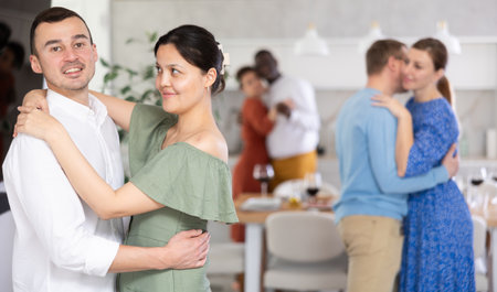 Men and women of different nationalities having fun dancing slow dance at house partyの写真素材