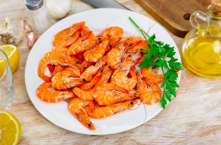 Chilled red prawns on plate with parsley, lemon, garlic and olive oilの写真素材