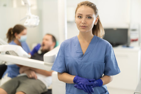 Female dental assistant standing in front of the officeの写真素材