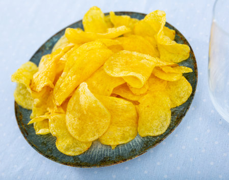 Crispy salty potato chips with natural taste on plateの写真素材