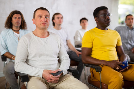 Adult male student listening to lecture with group
