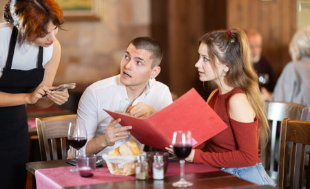 Waitress takes order from couple young man and woman