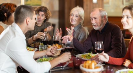 Large friendly family gathered at table to have lunch in restaurantの写真素材
