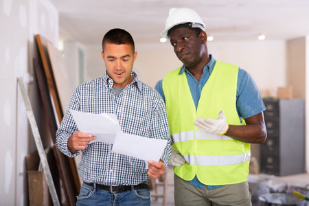 Architect and engineer having conversation about work plan in apartment
