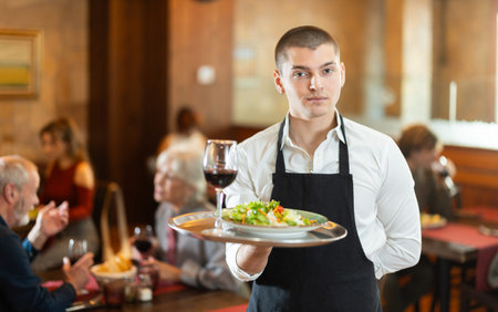 Guy waiter with tray in cafe hall