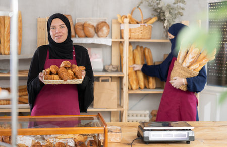 Young Muslim woman bakery owner offering fresh pastriesの写真素材