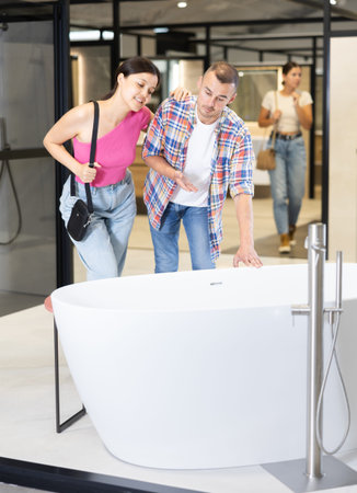 Married couple discussing bathtub colors in hardware store
