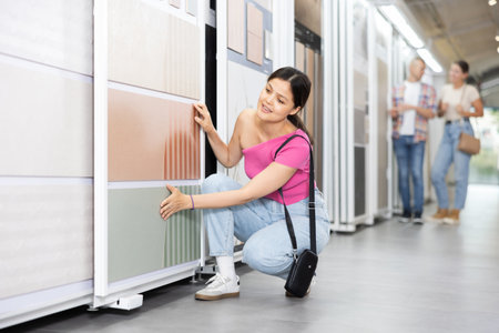 Young woman chooses tiles in hardware storeの写真素材
