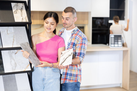 Husband and wife discussing the color of ceramic tiles for the bathroom in hardware storeの写真素材