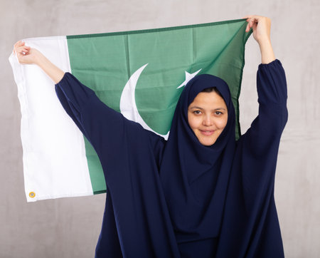 Young woman in hijab posing with Pakistan flagの写真素材