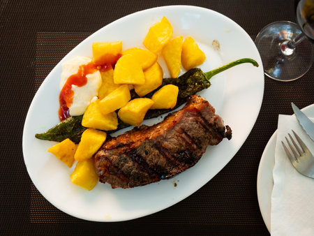 Fried beef served with potatoes and peppersの写真素材