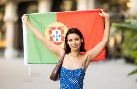 Young woman with portuguese flag on city streetの写真素材