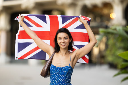 Young girl holding national flag of UK, standing outdoorsの写真素材