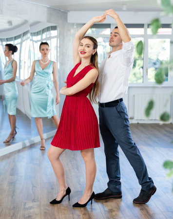 Couple in stage costumes learns boogie woogie dancing during individual lesson