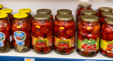 BADALONA, SPAIN - February 12, 2024: Glass jars with pickled tomatoes and cucumbers on the shelves of a Russian grocery store in Spain. Traditional Russian appetizerのeditorial素材