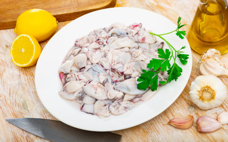 Raw squid, cut into pieces, for a tasty lunch with lemon and garlic.