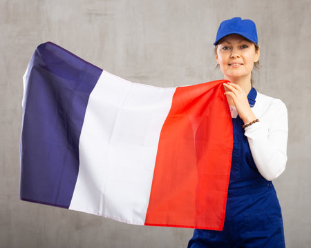 Smiling adult woman in uniform holding France flagの写真素材