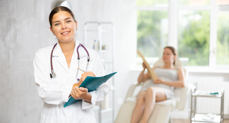 Young female doctor making notes in medical roomの写真素材