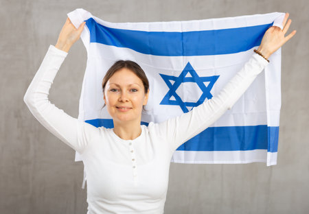 Pretty young girl holding Israel flag in her handsの写真素材