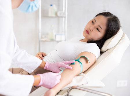 Middle-aged doctor giving injection into veinの写真素材