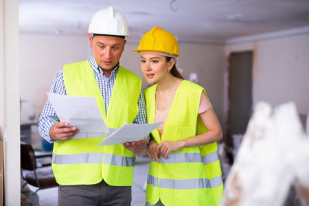 Woman engineer and man architect talking about documents