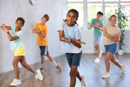 Boy perform choreographic exercises and teach energetic social dance waacking with friendsの写真素材