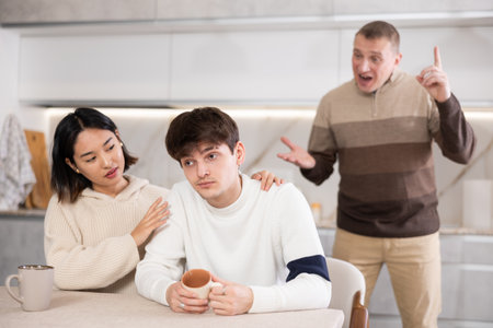 Adult man quarreling with young guy and womanの写真素材