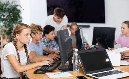 Focused girl studying with classmates in school classroom