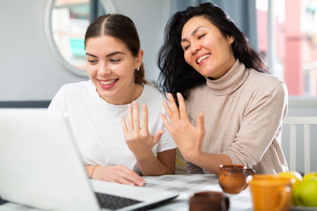Women showing wedding rings during video callの写真素材