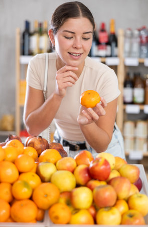 Young woman choosing fruit in grocery storeの写真素材