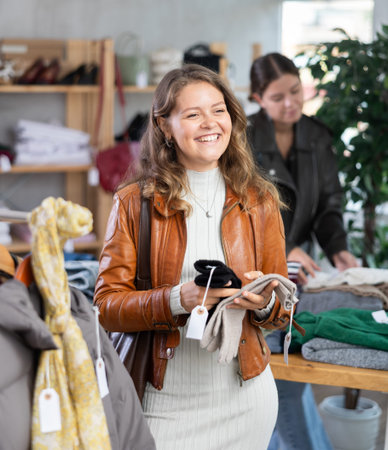 Young girl choosing winter gloves in clothing store