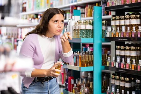 Girl with testers in perfumery, choosing perfume in cosmetic shopの写真素材