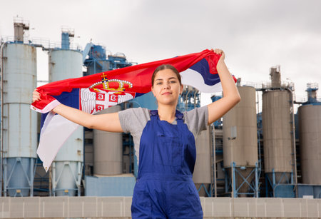 Confident young woman holds the national flag of Serbiaの写真素材