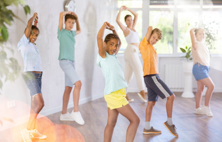 Active preteen children practicing Hip-hop dance with young trainerの写真素材