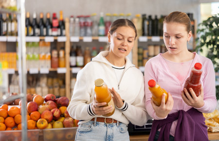 Young women choosing juices in grocery storeの写真素材
