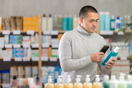 Young man scanning qr code of mouthwashの写真素材