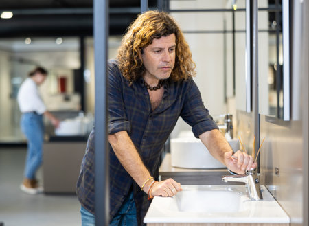 Confident man picking out new bathroom sink in hardware storeの写真素材