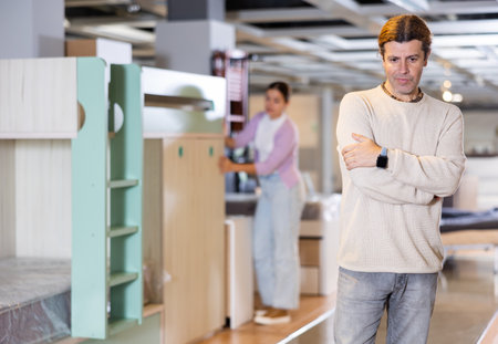 Confident man choosing wooden furniture in furniture showroomの写真素材