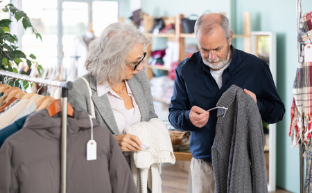 Mature couple spend time in shop and choose sweaterの写真素材