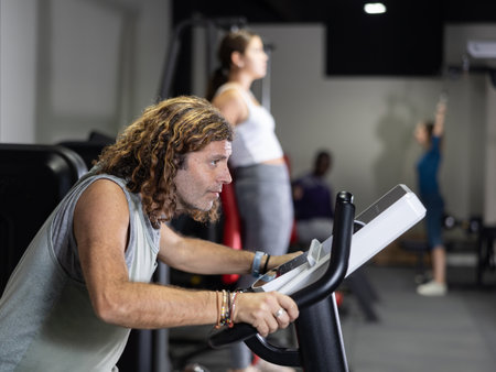 Man doing cardio workout, training on exercise bikeの写真素材