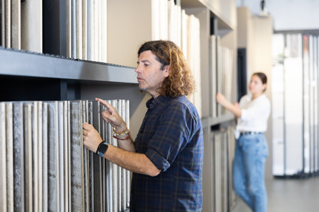 Focused man choosing wall tiling materials in hardware shopの写真素材