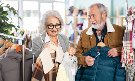 Family clothing store, senior couple customer chooses jacket or coatの写真素材
