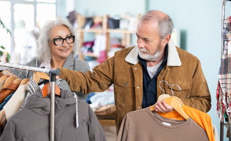 elderly couple chooses T shirts for every dayの写真素材