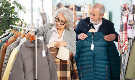 Elderly couple choosing jackets and coats togetherの写真素材