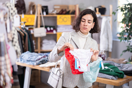 Positive female client choosing new panties in lingerie storeの写真素材