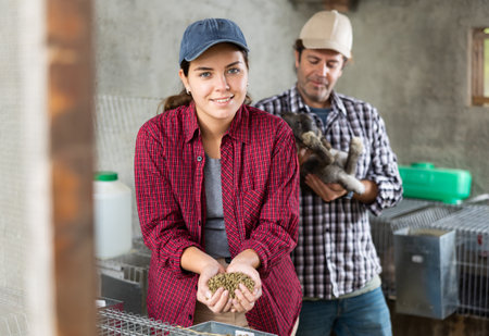 Family business - man and woman breed rabbits on farmの写真素材